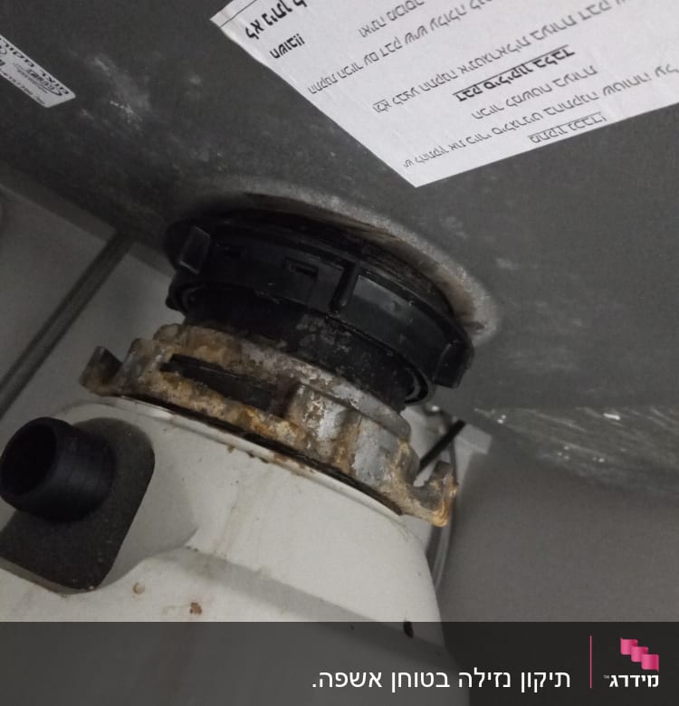 חיבור צינור מתכת עם חלודה מתחת לכיור